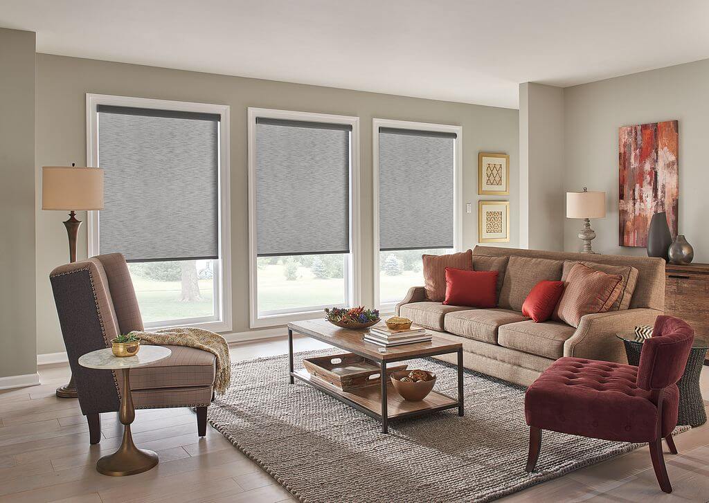 Roller shades in a living room, shown in a warm neutral fabric
